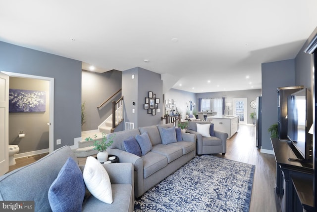 living room with stairway, recessed lighting, wood finished floors, and baseboards