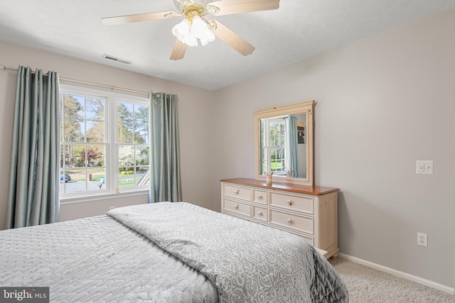 bedroom with light carpet, visible vents, baseboards, and ceiling fan