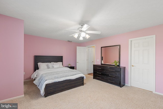 bedroom with light colored carpet, baseboards, and a ceiling fan