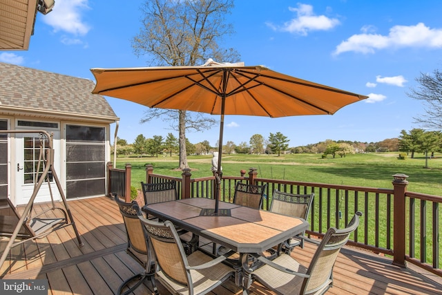 wooden deck with a yard and outdoor dining area