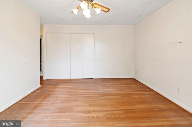 unfurnished bedroom with a closet, light wood-style flooring, baseboards, and ceiling fan