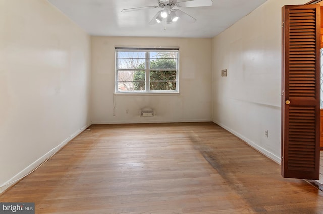 unfurnished room featuring a ceiling fan, light wood-type flooring, and baseboards