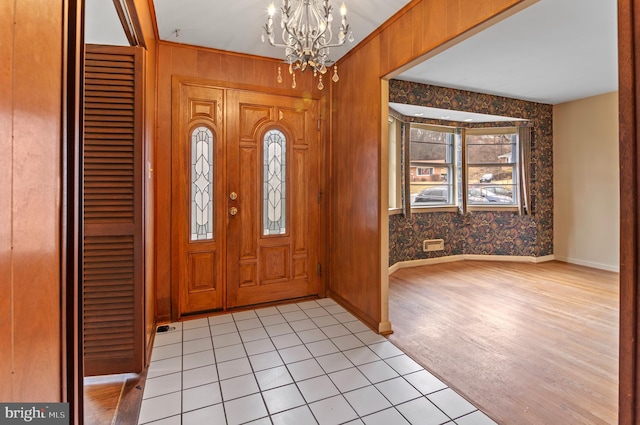 entrance foyer featuring wallpapered walls, baseboards, and an inviting chandelier