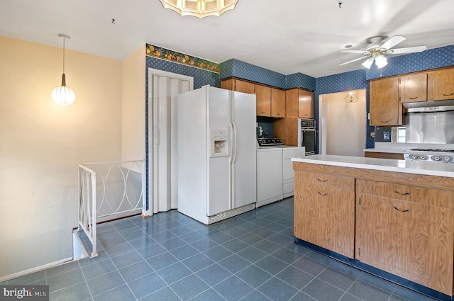 kitchen featuring independent washer and dryer, under cabinet range hood, black oven, white fridge with ice dispenser, and wallpapered walls