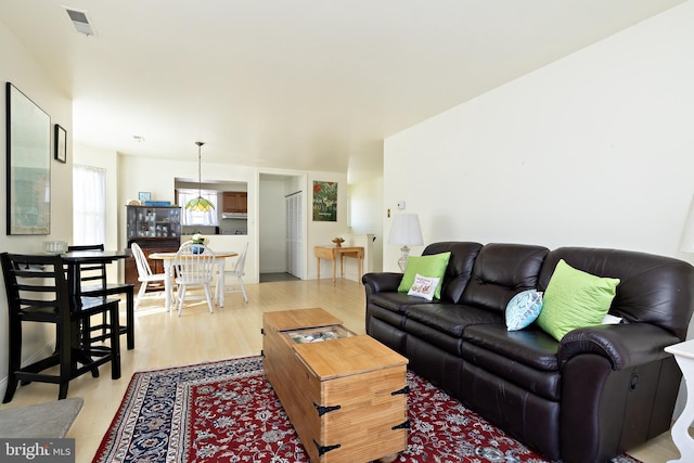 living room with visible vents and light wood-style flooring