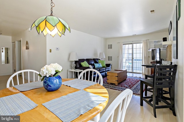 dining area with visible vents and light wood finished floors