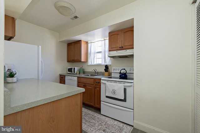 kitchen with visible vents, a sink, under cabinet range hood, white appliances, and light countertops