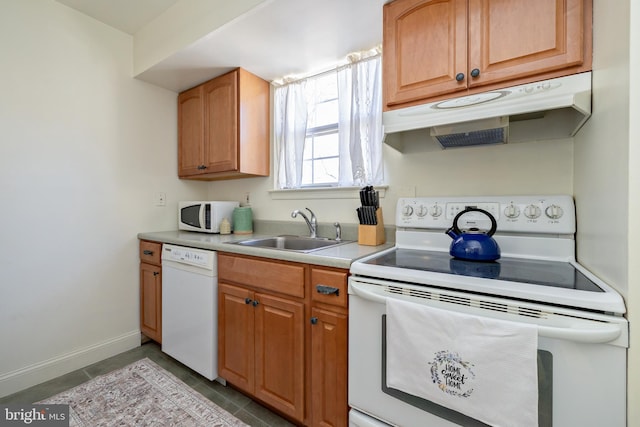 kitchen with white appliances, baseboards, a sink, light countertops, and under cabinet range hood