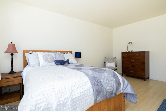 bedroom with baseboards and light wood-type flooring