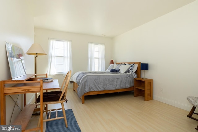 bedroom with baseboards and wood finished floors