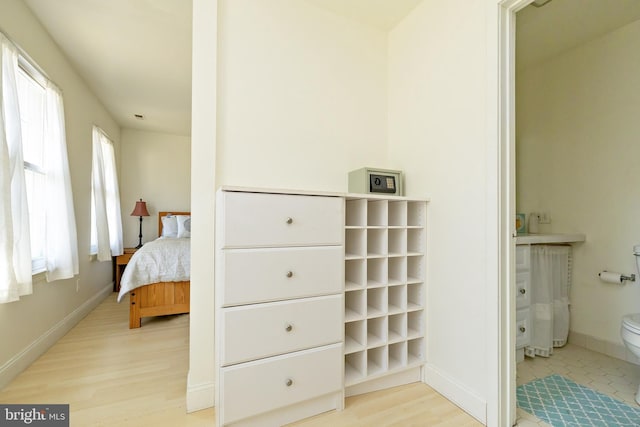 bedroom with light wood-style floors and baseboards