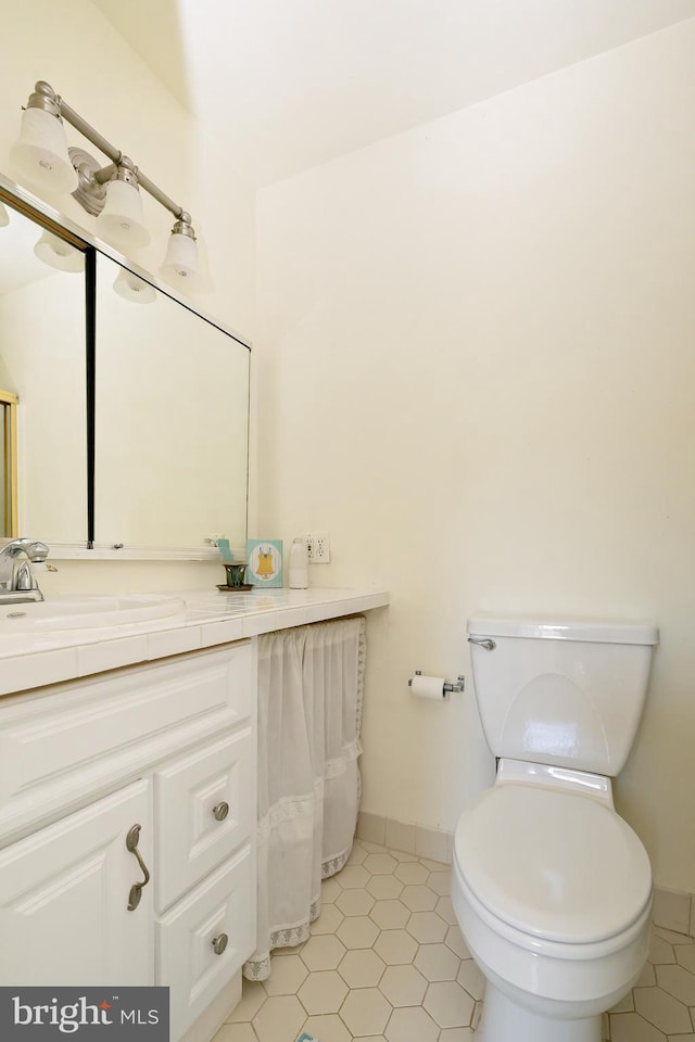 bathroom with vanity, tile patterned floors, toilet, and baseboards