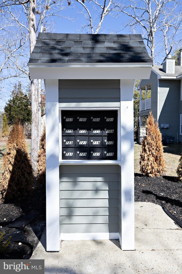 exterior details with mail area and a shingled roof