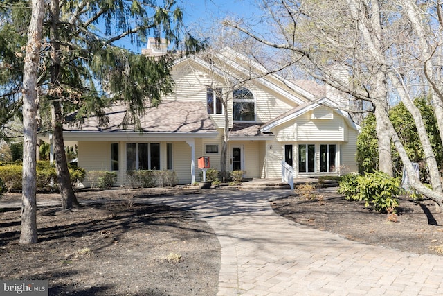 view of front of home with driveway and a chimney