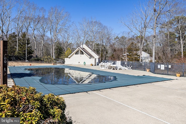 pool with a patio area and fence