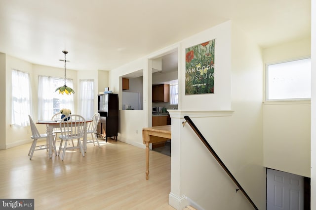 dining area featuring baseboards and light wood-style floors