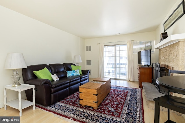 living area featuring visible vents and wood finished floors