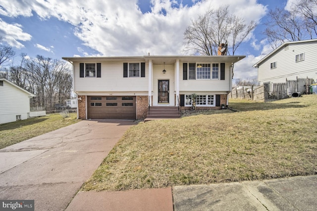 split foyer home featuring driveway, fence, an attached garage, a front yard, and brick siding