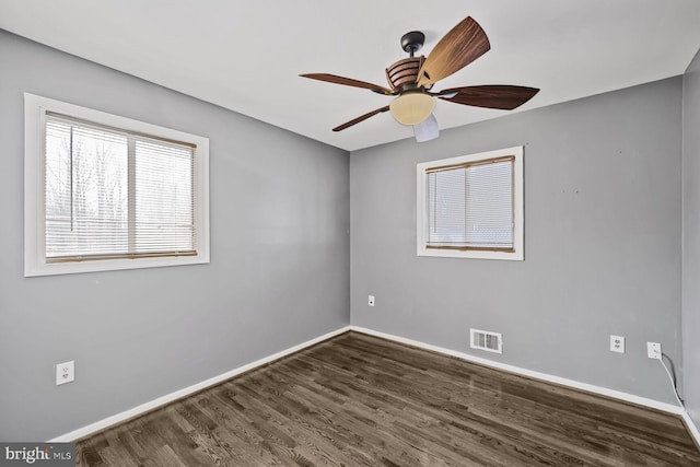 spare room with visible vents, a ceiling fan, baseboards, and wood finished floors