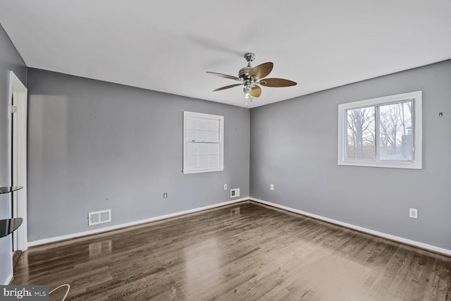 unfurnished room featuring visible vents, wood finished floors, baseboards, and ceiling fan