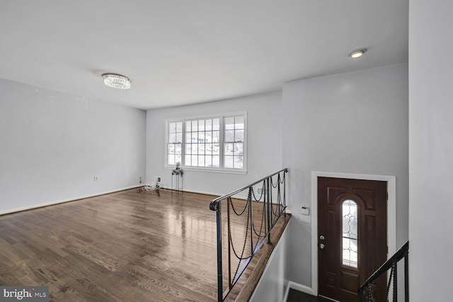 foyer entrance with stairway, wood finished floors, and baseboards