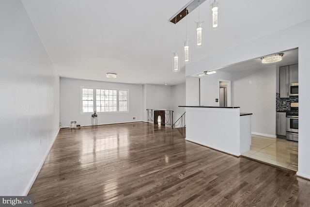 unfurnished living room with wood finished floors and baseboards