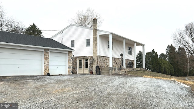 view of front of property featuring stone siding and driveway