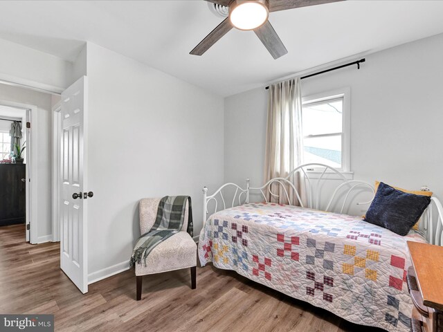 bedroom with a ceiling fan, baseboards, and wood finished floors