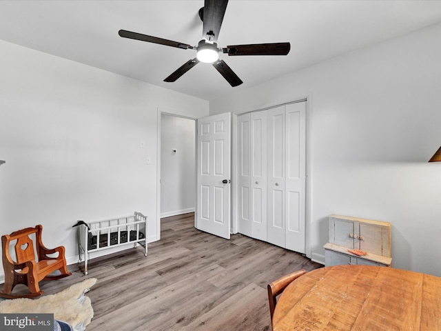 bedroom with a closet, ceiling fan, baseboards, and wood finished floors