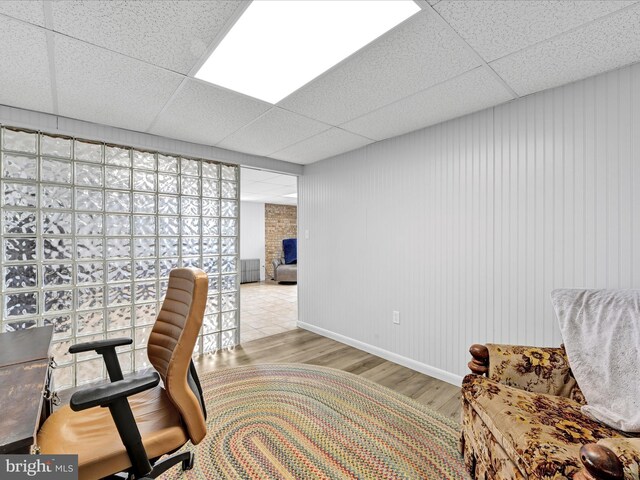 office area with a paneled ceiling and wood finished floors