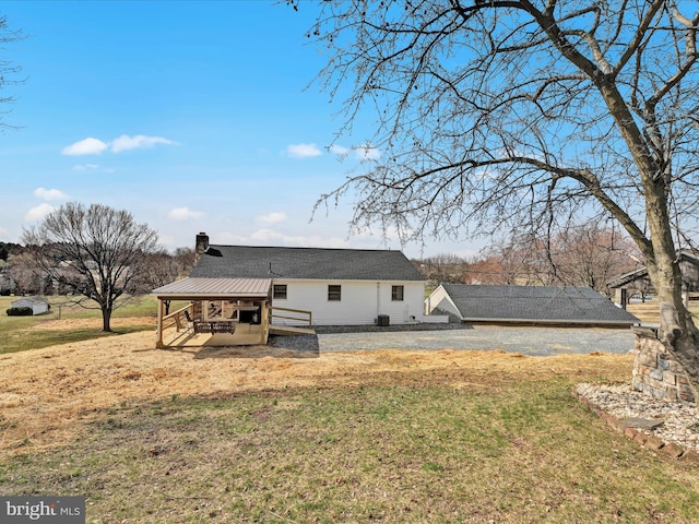 back of property featuring a yard and a chimney