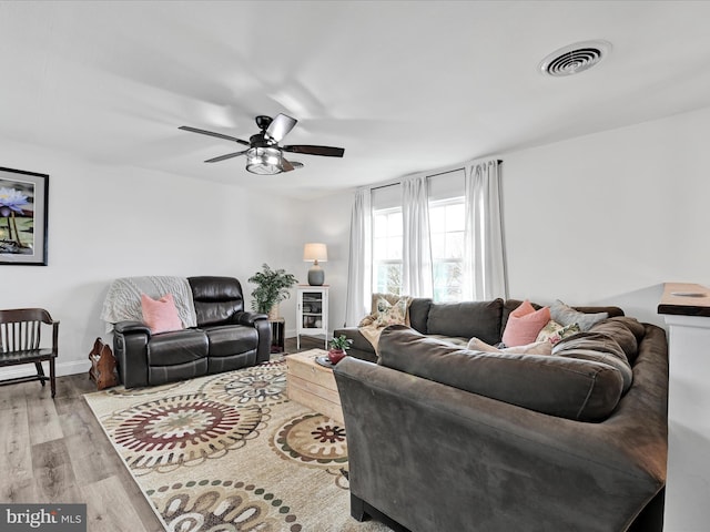 living room featuring baseboards, wood finished floors, visible vents, and ceiling fan