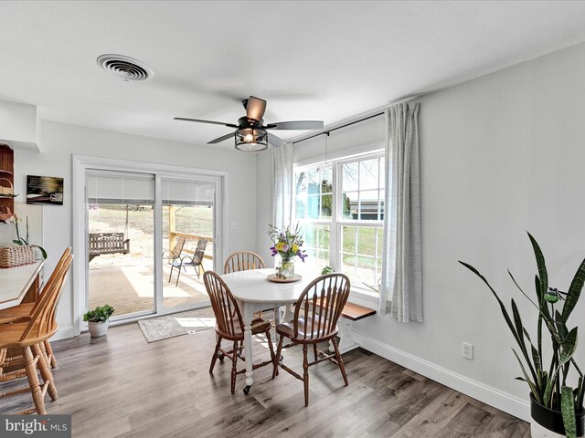 dining area with visible vents, ceiling fan, baseboards, and wood finished floors