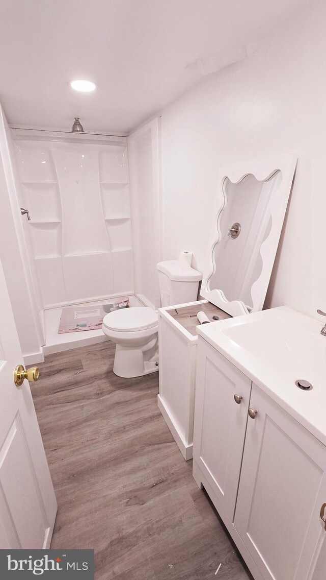 215 W Hilltop Rd, Brooklyn Park, MD 21225 - bathroom with toilet, vanity, a stall shower, and wood finished floors