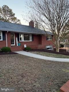 view of front of house with brick siding and a chimney