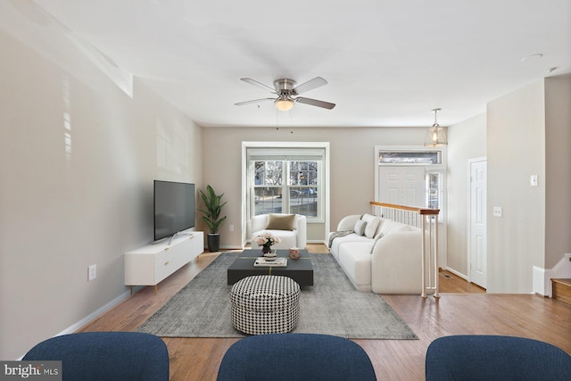 living area featuring a ceiling fan, wood finished floors, and baseboards