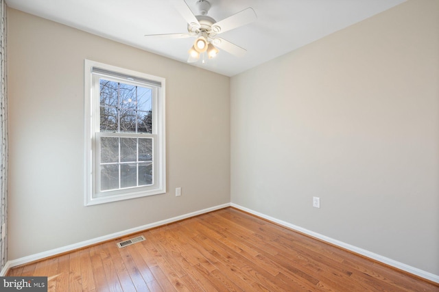 empty room featuring visible vents, ceiling fan, baseboards, and wood-type flooring