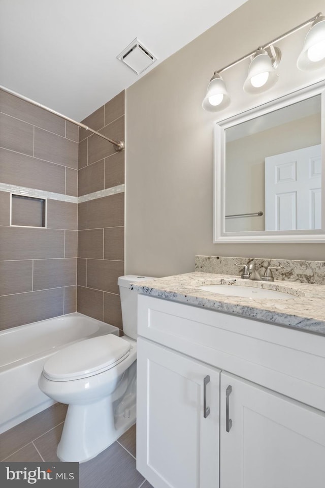 bathroom featuring visible vents, toilet,  shower combination, and vanity