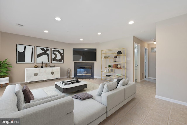 tiled living area with recessed lighting, visible vents, baseboards, and a glass covered fireplace