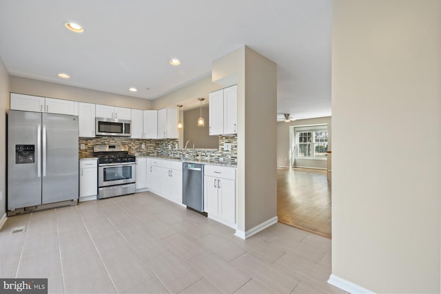 kitchen featuring a sink, ceiling fan, white cabinets, appliances with stainless steel finishes, and tasteful backsplash