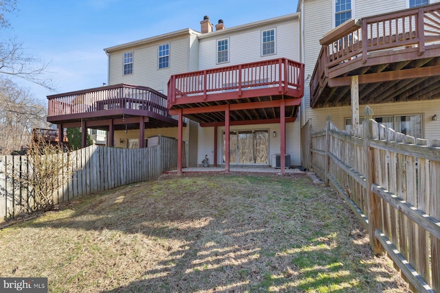 rear view of house with a fenced backyard, a lawn, central AC, and a chimney