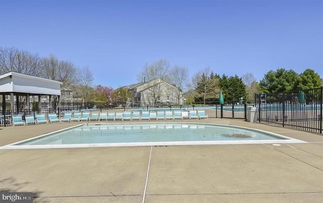 pool with a patio and fence