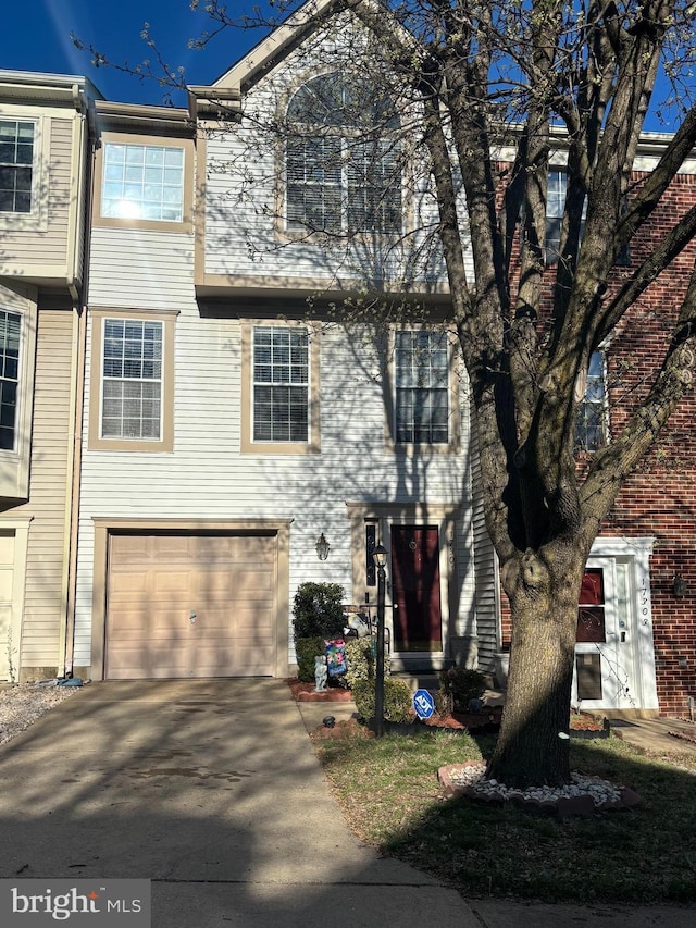 multi unit property with concrete driveway and a garage