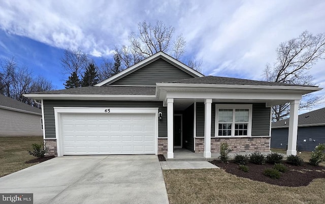 view of front of house with a garage, stone siding, and driveway