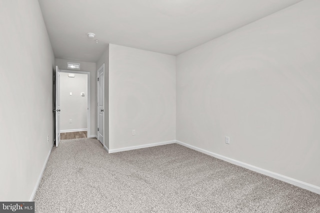 carpeted empty room with baseboards