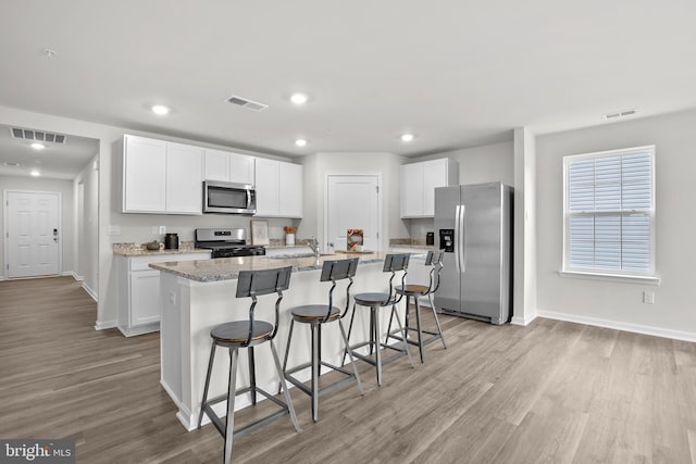 kitchen featuring visible vents, appliances with stainless steel finishes, and white cabinetry