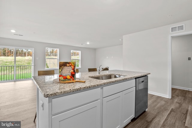 kitchen featuring light stone countertops, a center island with sink, visible vents, a sink, and stainless steel dishwasher