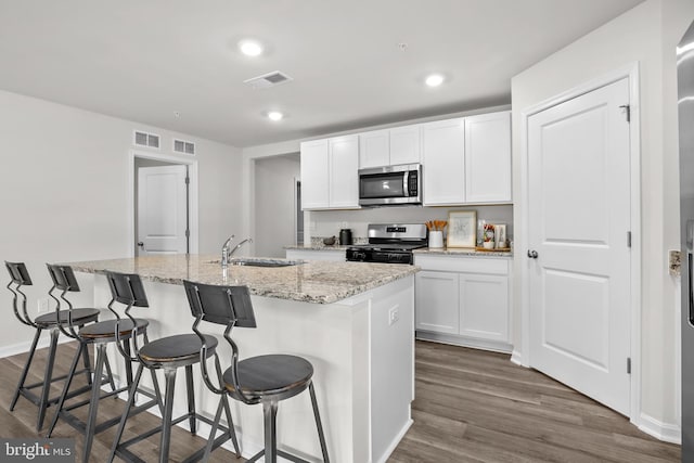 kitchen featuring visible vents, white cabinets, appliances with stainless steel finishes, and a sink