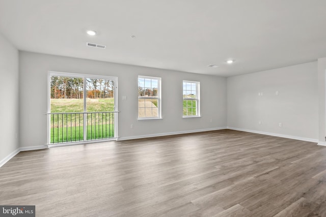 interior space with recessed lighting, wood finished floors, visible vents, and baseboards