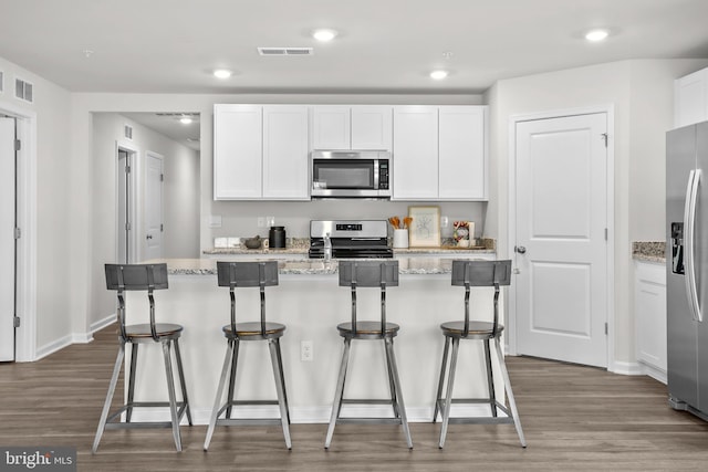 kitchen with stainless steel appliances, visible vents, and white cabinets